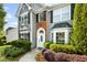 Close-up of home's entrance with brick accents, white door and trim, and mature landscaping at 2360 Brookgreen Commons, Kennesaw, GA 30144