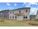 A spacious backyard featuring a covered patio, lush green lawn, and neutral siding on a two-story home at 537 Teversham Dr, Mcdonough, GA 30253