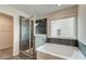 Modern bathroom featuring a shower, a soaking tub, and a large window at 537 Teversham Dr, Mcdonough, GA 30253