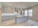 Well-lit kitchen with grey cabinets, stainless steel appliances, and a functional island featuring a sink at 537 Teversham Dr, Mcdonough, GA 30253