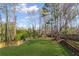 A large, grassy backyard is surrounded by a privacy fence and mature trees at 5635 Charleston Bay Dr, Cumming, GA 30041