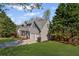 Side view of a two-story home with a well-maintained lawn, two-car garage, and inviting covered front porch at 5635 Charleston Bay Dr, Cumming, GA 30041