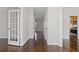 Hallway with gleaming hardwood floors, white trim, and views into other rooms of the house at 5635 Charleston Bay Dr, Cumming, GA 30041