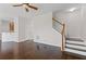Cozy living room with hardwood floors, staircase, and view into the kitchen at 5635 Charleston Bay Dr, Cumming, GA 30041