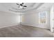 Spacious main bedroom with tray ceiling, two windows, neutral walls, and carpet flooring at 5635 Charleston Bay Dr, Cumming, GA 30041