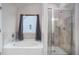 Elegant bathroom featuring a soaking tub under a window and a glass-enclosed shower at 224 Osier Dr, Mcdonough, GA 30252