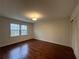 Bedroom features hardwood floors, neutral walls, and a window with views of the trees outside at 257 Forest Lake Rd, Lawrenceville, GA 30046