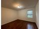 Bedroom features hardwood floors, neutral walls, and a window overlooking a green space at 257 Forest Lake Rd, Lawrenceville, GA 30046