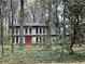 Charming home with a bright red front door nestled among mature trees and lush greenery at 257 Forest Lake Rd, Lawrenceville, GA 30046