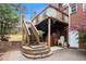 A brick home featuring an elevated deck with basketball hoop and a paver patio below at 4236 Providence Ln, Tucker, GA 30084