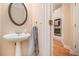 Charming half-bathroom with a pedestal sink, hardwood floors, and views to the kitchen at 4236 Providence Ln, Tucker, GA 30084
