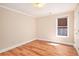 A simple bedroom with wood-look floors and a window offers comfortable living space at 4236 Providence Ln, Tucker, GA 30084