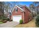 Brick home with a two-car garage, manicured lawn, and mature trees at 4236 Providence Ln, Tucker, GA 30084