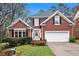 Charming brick home featuring a manicured lawn, two-car garage, and traditional architectural details at 4236 Providence Ln, Tucker, GA 30084