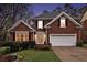 Charming brick home featuring a manicured lawn, two-car garage, and traditional architectural details at 4236 Providence Ln, Tucker, GA 30084