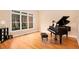 Bright living room with hardwood floors, a large window, and a grand piano at 4236 Providence Ln, Tucker, GA 30084