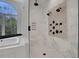 Upscale shower with a window, marble tiling, and multiple shower heads at 821 Camden Park Ct, Atlanta, GA 30342