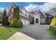 Beautiful brick home featuring a three-car garage, manicured lawn, and a spacious driveway at 821 Camden Park Ct, Atlanta, GA 30342