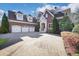 Beautiful brick home featuring a three-car garage, manicured landscaping, and a charming front entrance at 821 Camden Park Ct, Atlanta, GA 30342