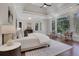 Serene main bedroom featuring hardwood floors, tray ceiling, and abundant natural light from large windows at 821 Camden Park Ct, Atlanta, GA 30342