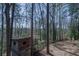 View of backyard with mature trees, a rustic wooden structure, and partial wooden fence at 725 Glengary Ne Way, Atlanta, GA 30342