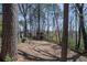 View of backyard with mature trees, a rustic wooden structure, stone wall and back of home at 725 Glengary Ne Way, Atlanta, GA 30342
