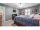 Neutral bedroom featuring a ceiling fan, window with closed blinds, and dark furniture with coordinating bedding at 725 Glengary Ne Way, Atlanta, GA 30342