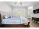 Well-lit bedroom featuring a bed with a tufted headboard, ceiling fan, and an open view to the next room at 3371 Dogwood Dr # 220, Hapeville, GA 30354