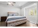 Bright bedroom with a tufted headboard bed, ceiling fan, and large windows allowing for natural light at 3371 Dogwood Dr # 220, Hapeville, GA 30354