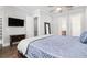 Spacious bedroom featuring a bed with a tufted headboard, ceiling fan, tv and doorways to other rooms at 3371 Dogwood Dr # 220, Hapeville, GA 30354
