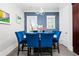 Formal dining area features a sleek white table, seating for six, designer lighting and a view of the home's exterior at 3371 Dogwood Dr # 220, Hapeville, GA 30354