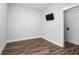 Clean, bright, empty room with wood-look floors and a mounted television at 3371 Dogwood Dr # 220, Hapeville, GA 30354