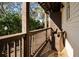 Cozy outdoor porch with wooden columns, seating, and view of the surrounding trees at 3371 Dogwood Dr # 220, Hapeville, GA 30354