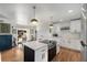 Modern kitchen with an island cooktop, pendant lighting, white cabinetry, and hardwood floors at 2382 Whites Mill Ln, Decatur, GA 30032