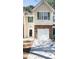 Exterior view of a charming townhome featuring stone accents, siding, and green shuttered windows at 5740 Terremont Cir, Norcross, GA 30093
