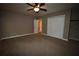 This bedroom features neutral walls and carpet, ceiling fan, closet space, and an adjacent doorway at 1075 Winding Branch Ln, Atlanta, GA 30338
