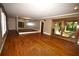 Open-concept living room with wood floors, a stone wall, and sliding glass doors to a porch at 1075 Winding Branch Ln, Atlanta, GA 30338