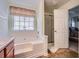 Bright bathroom with a soaking tub, shower, and an open doorway to the main bedroom at 1312 Birch Ct, Lithonia, GA 30058