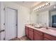 Bathroom featuring a double vanity, large mirror, and a view to the main bedroom at 1312 Birch Ct, Lithonia, GA 30058