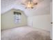 Bright, carpeted bedroom featuring textured ceiling, a large window, and a ceiling fan at 1312 Birch Ct, Lithonia, GA 30058