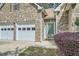 Close-up of home's entrance, two car garage, brick exterior and manicured landscaping at 1312 Birch Ct, Lithonia, GA 30058