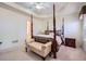 Inviting main bedroom with a four-poster bed, carpet, and an elegant bench at 1312 Birch Ct, Lithonia, GA 30058