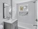 Stylish bathroom featuring modern fixtures, a gray vanity, and a bathtub with white tile surround at 1328 Sharon Street Nw, Atlanta, GA 30314