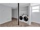 Bright laundry room featuring a modern washer and dryer, and neutral wall and floor tiles at 1328 Sharon Street Nw, Atlanta, GA 30314