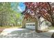 Side view of a charming home featuring an attached garage, a well-maintained driveway, and a beautifully landscaped yard at 195 Creekside Way, Mcdonough, GA 30252