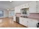 Well-lit kitchen features white cabinets and stainless steel appliances, offering a practical and stylish space at 195 Creekside Way, Mcdonough, GA 30252