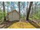Outdoor shed with a closed single door in a wooded area at 195 Creekside Way, Mcdonough, GA 30252