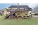 Expansive backyard with lush green grass, tiered decks, and mature trees providing shade at 802 Towering Pine Trl, Lawrenceville, GA 30045