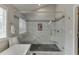 Bright bathroom featuring a large shower with marble-style tiles, a window, and a shower seat at 802 Towering Pine Trl, Lawrenceville, GA 30045