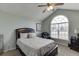 Bright bedroom boasts vaulted ceiling, large arched window, and a comfy king-sized bed with stylish bedding at 802 Towering Pine Trl, Lawrenceville, GA 30045